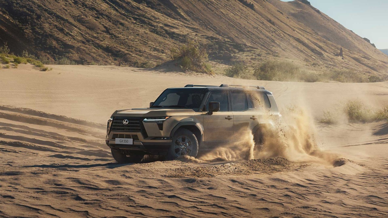 A Lexus GX driving on sand